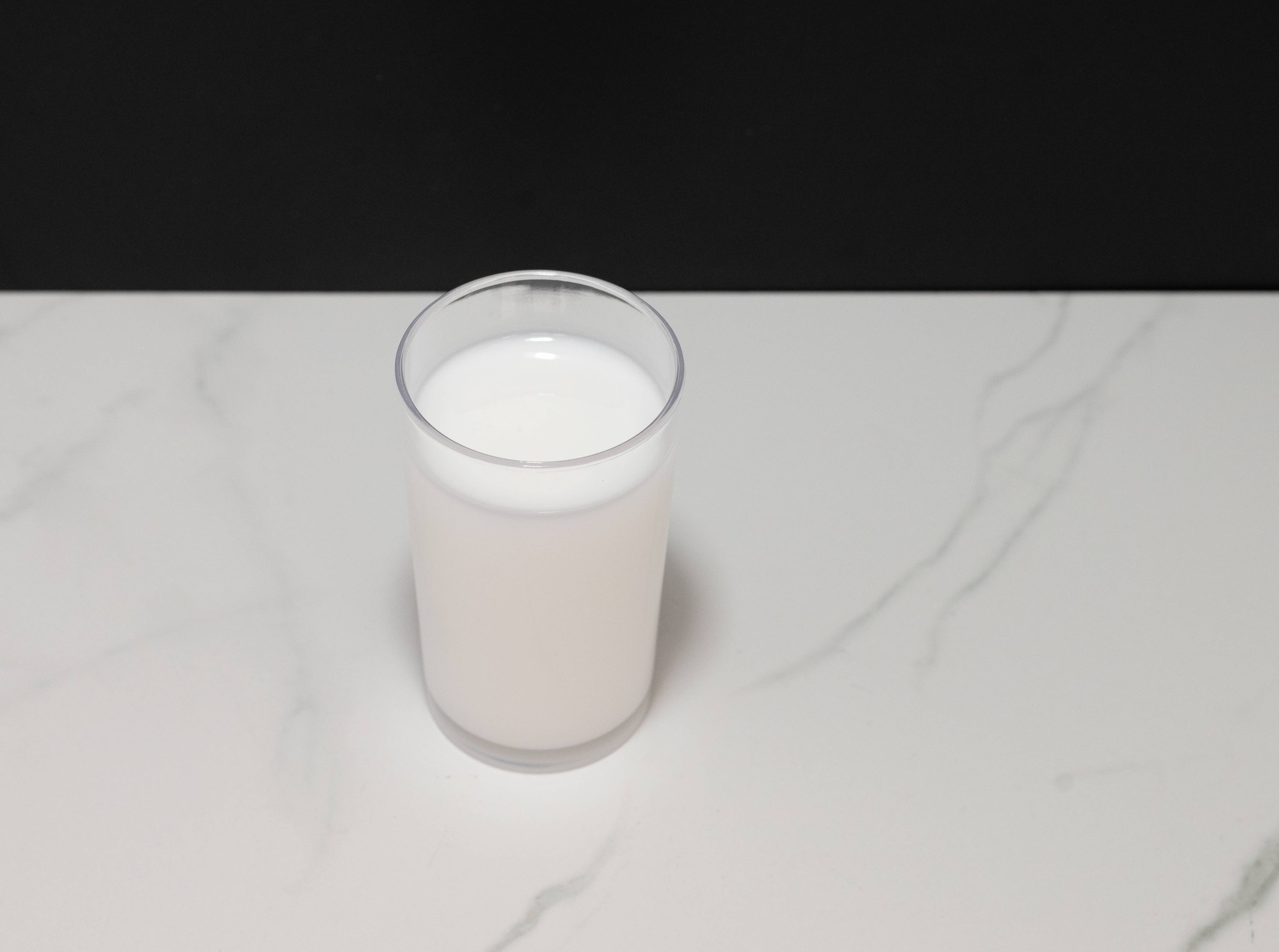 Fake glass of milk — angled view showing glass shape and faux liquid