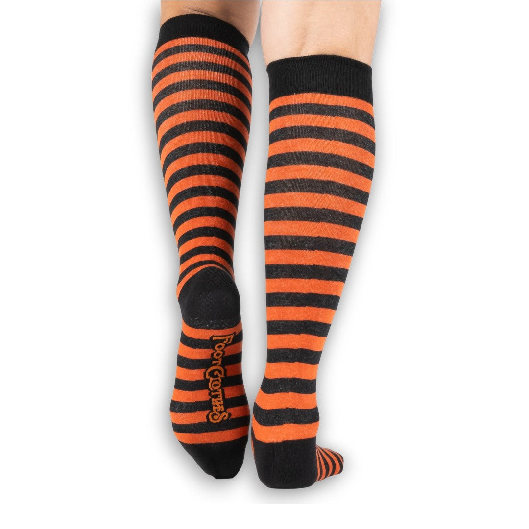 Pumpkin orange and black striped knee high socks — model close-up leg detail