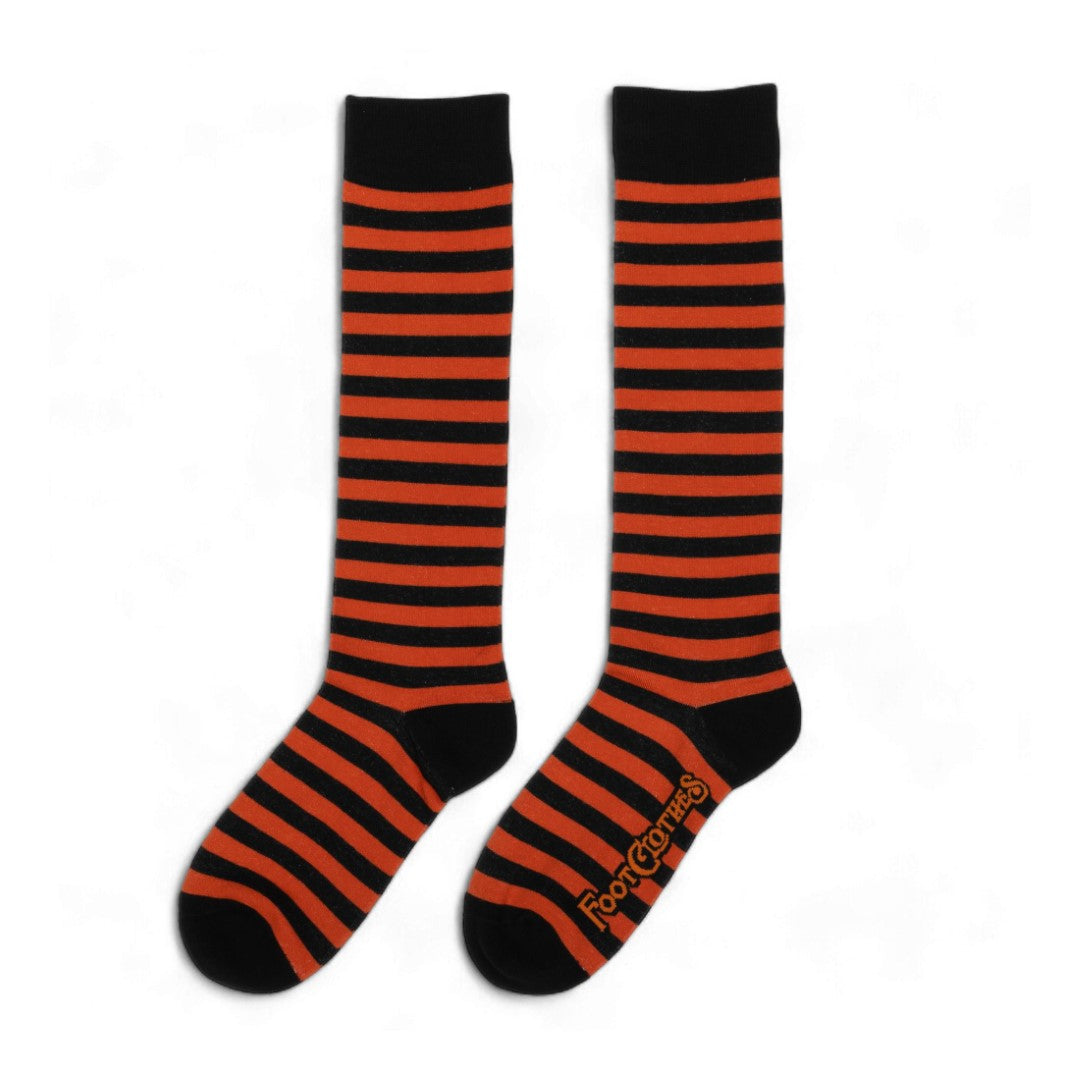 Pumpkin orange and black striped knee high socks — left sock flat lay