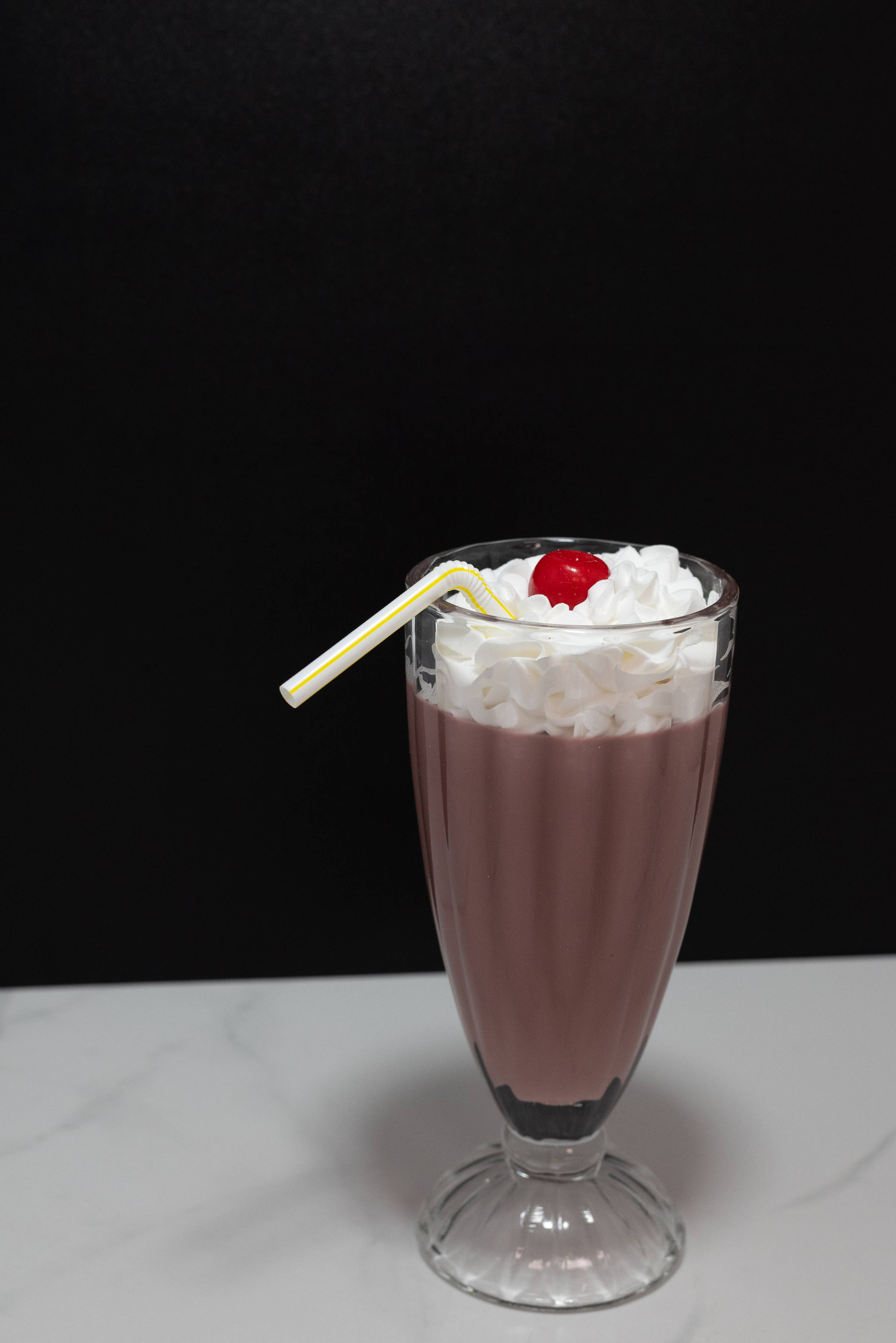 Fake chocolate milkshake — side view showing diner glass shape and full height