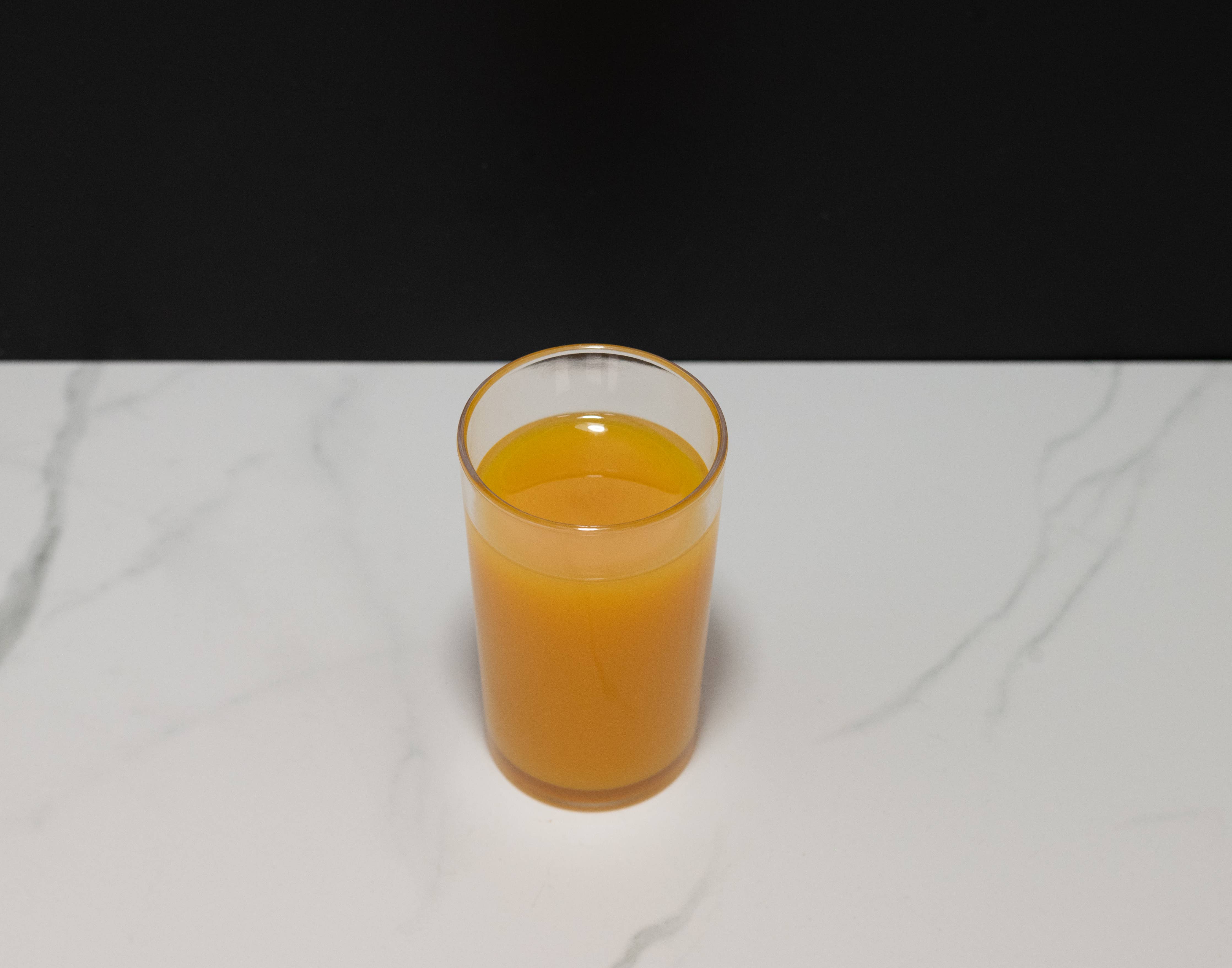 Fake glass of orange juice — top-down view showing surface texture detail