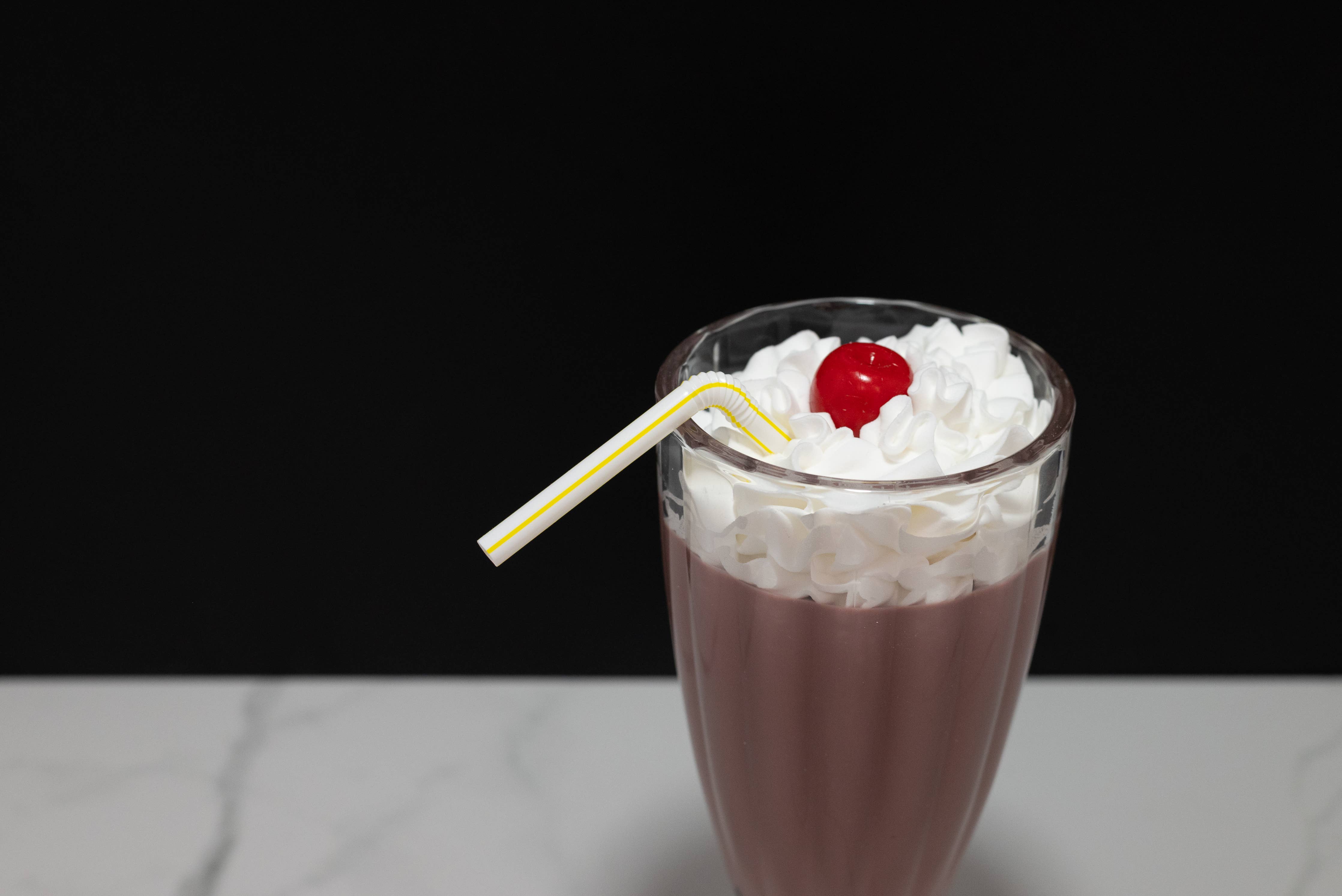 Fake chocolate milkshake — top-down view of whipped cream and cherry topper