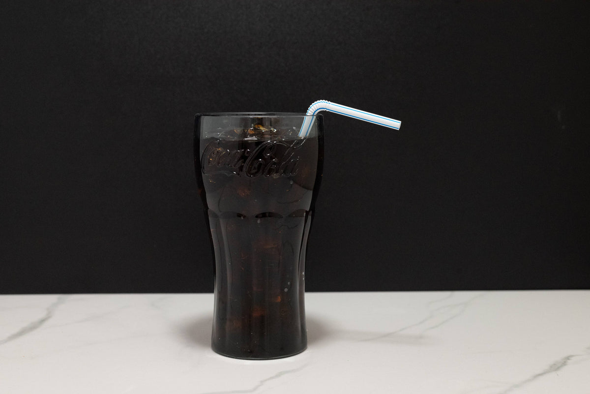 Top-down view of fake Coca-Cola glass display showing ice and soda surface replica