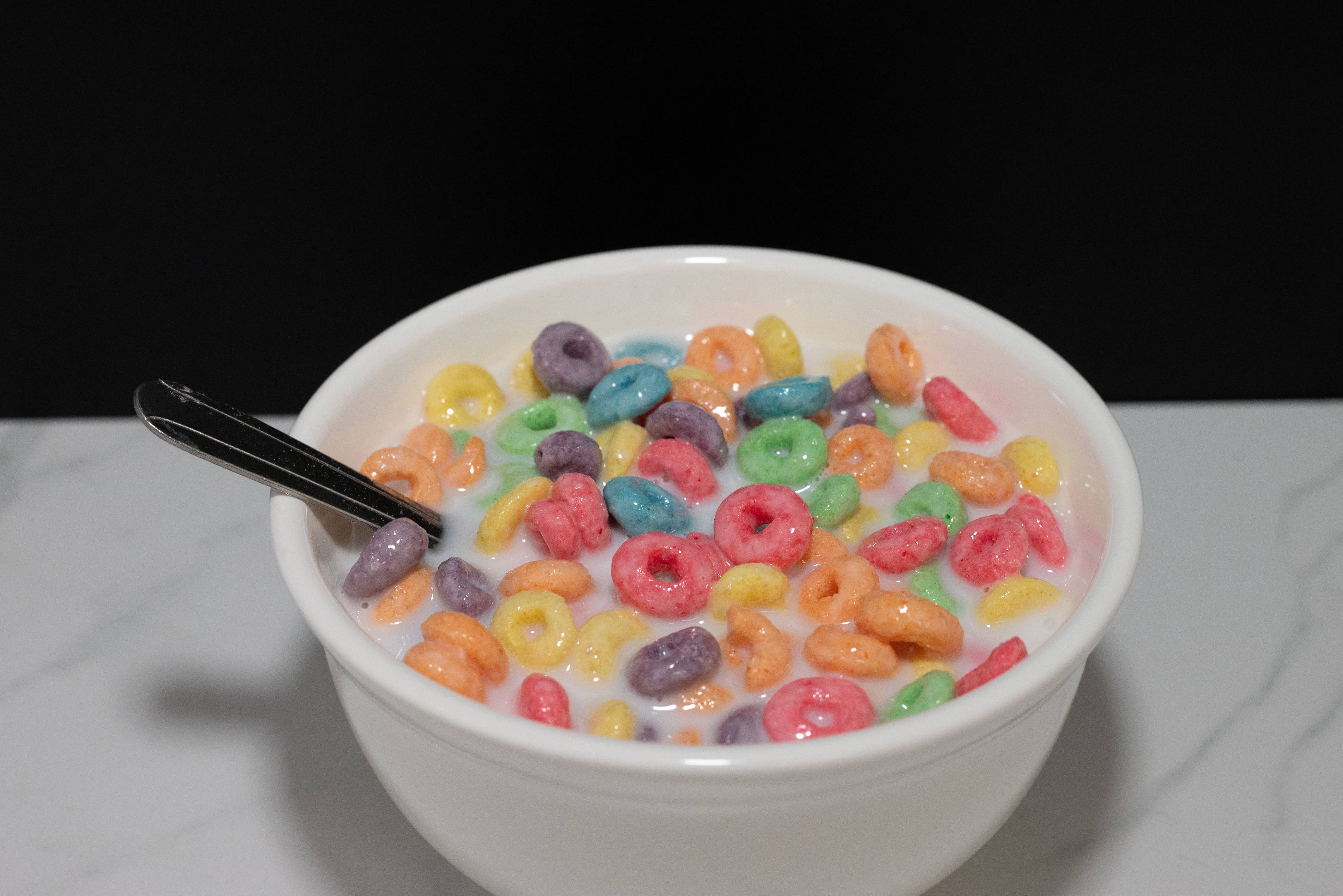 Fake Fruit Loops cereal bowl — angled view showing spoon and bowl depth