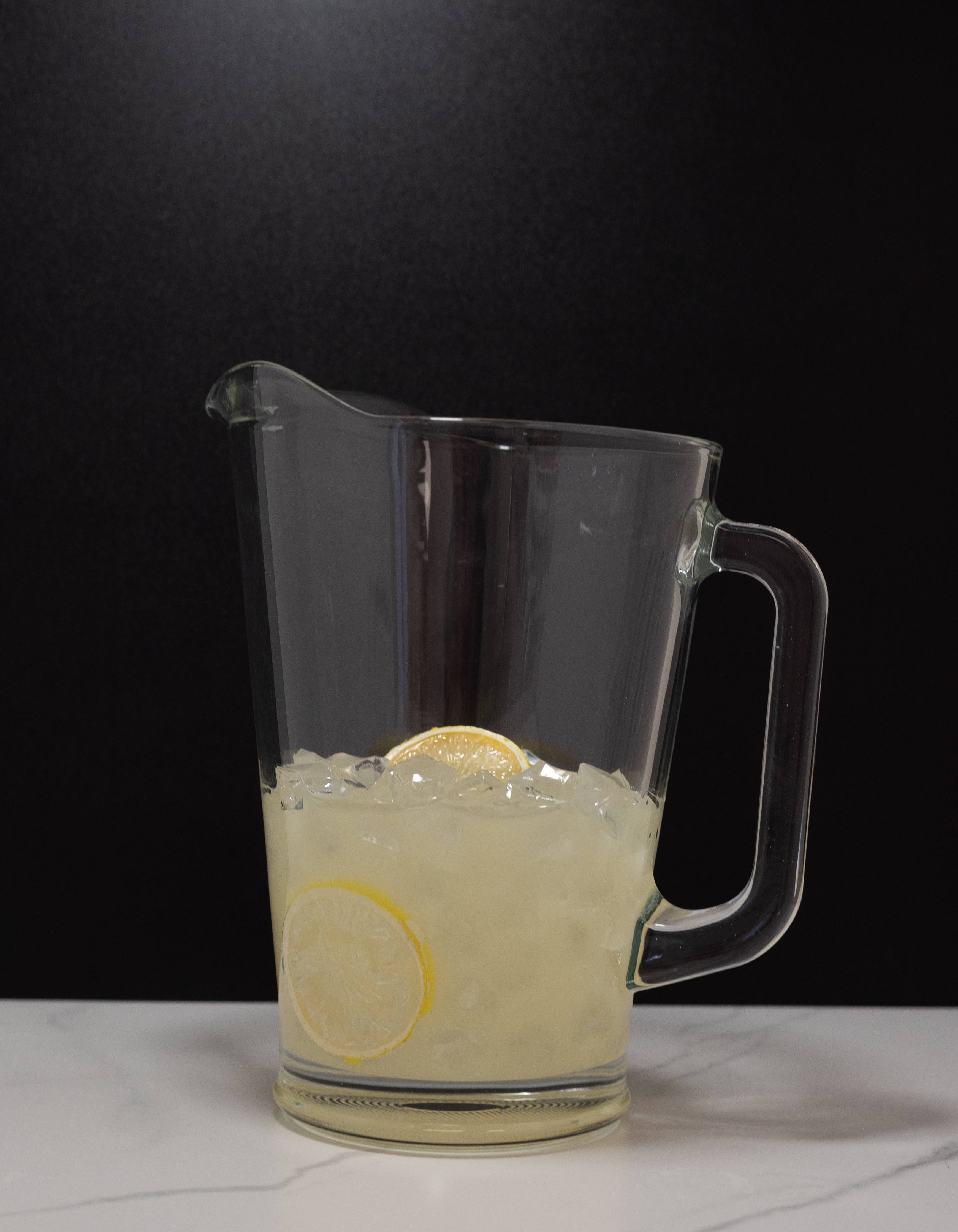 Fake iced lemonade pitcher — side view showing realistic lemonade color and condensation detail
