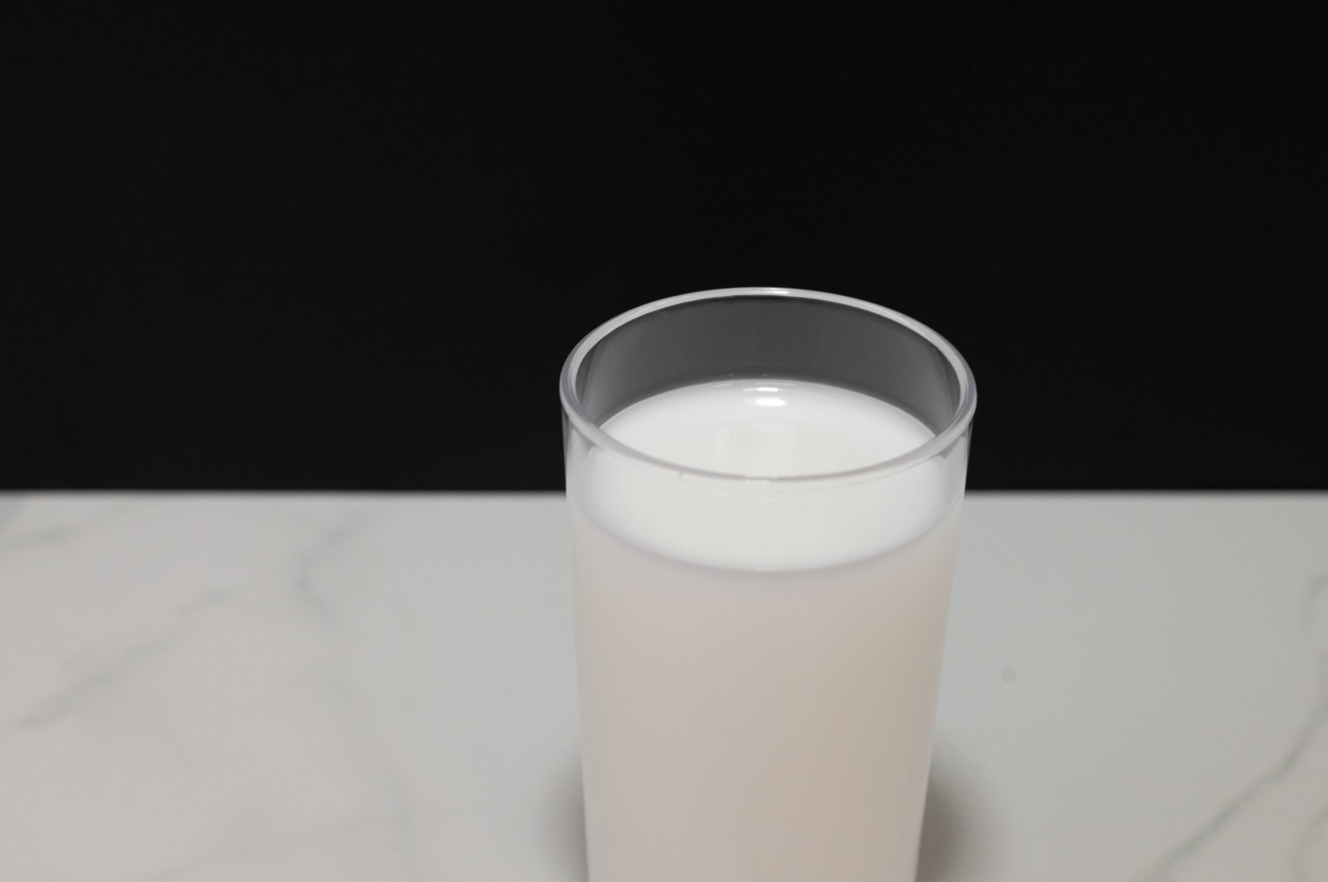 Fake glass of milk paired with milk carafe for display context
