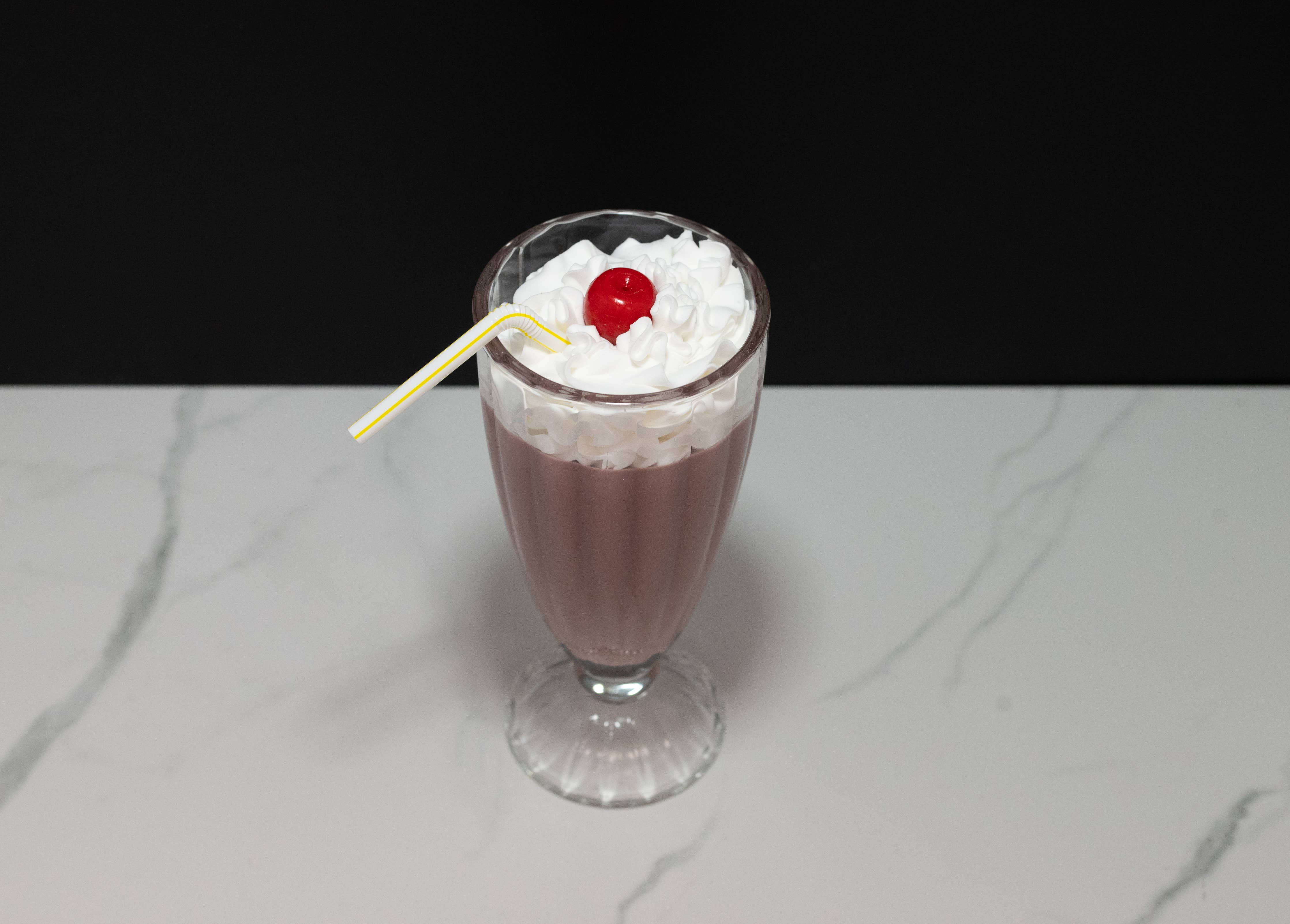 Fake chocolate milkshake — close-up of chocolate shake, whipped cream, and cherry