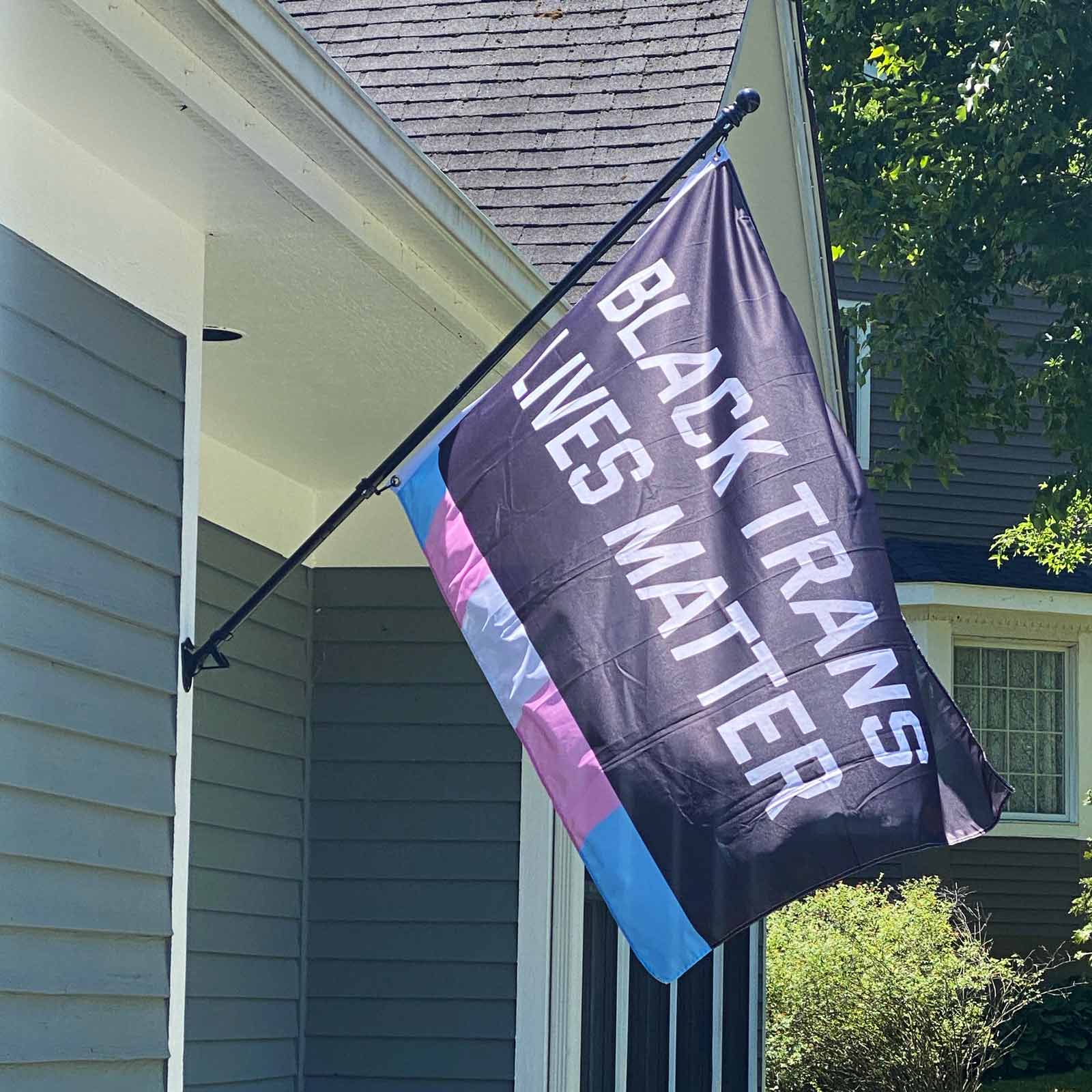 Black Trans Lives Matter flag displayed on a house exterior