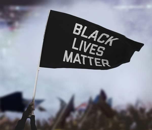 Black Lives Matter flag — carried at protest, crowd visible