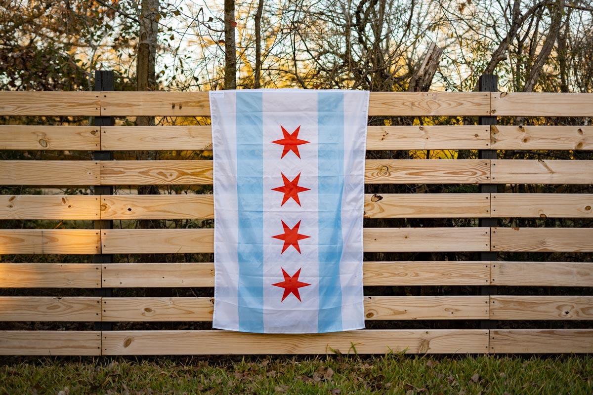 Chicago Flag displayed on a chain-link fence outdoors
