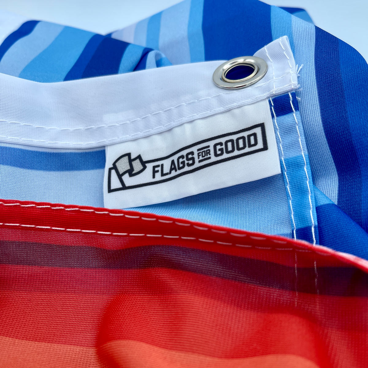 Climate Warming Stripes flag — sewn-in tag detail with care and construction information