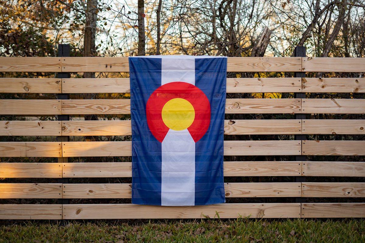 Colorado State Flag — displayed on an outdoor fence