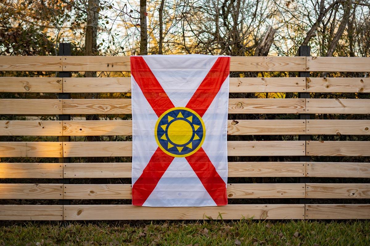 Florida Sunshine Flag — displayed on outdoor fence