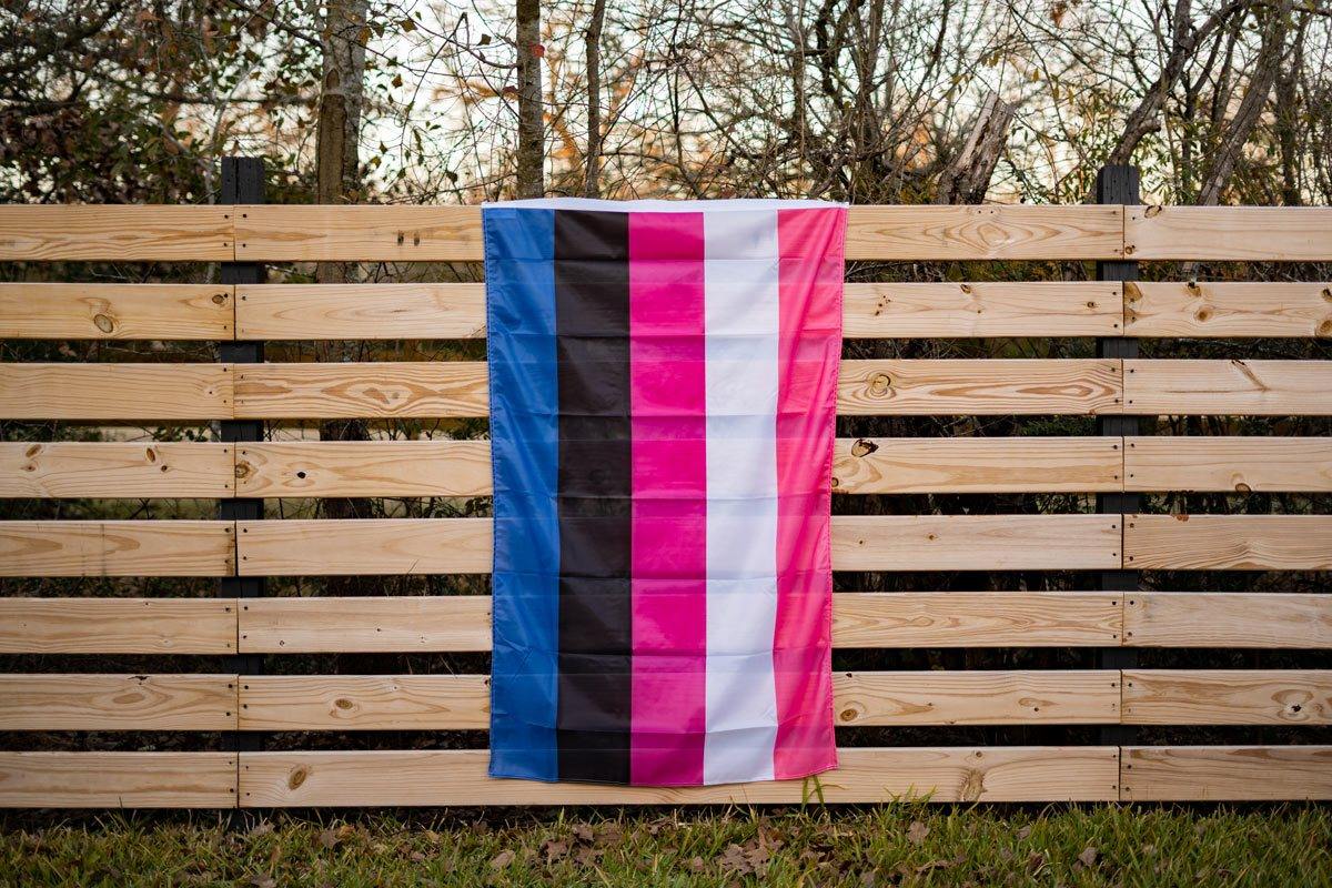 Gender Fluid Pride Flag displayed on fence outdoors