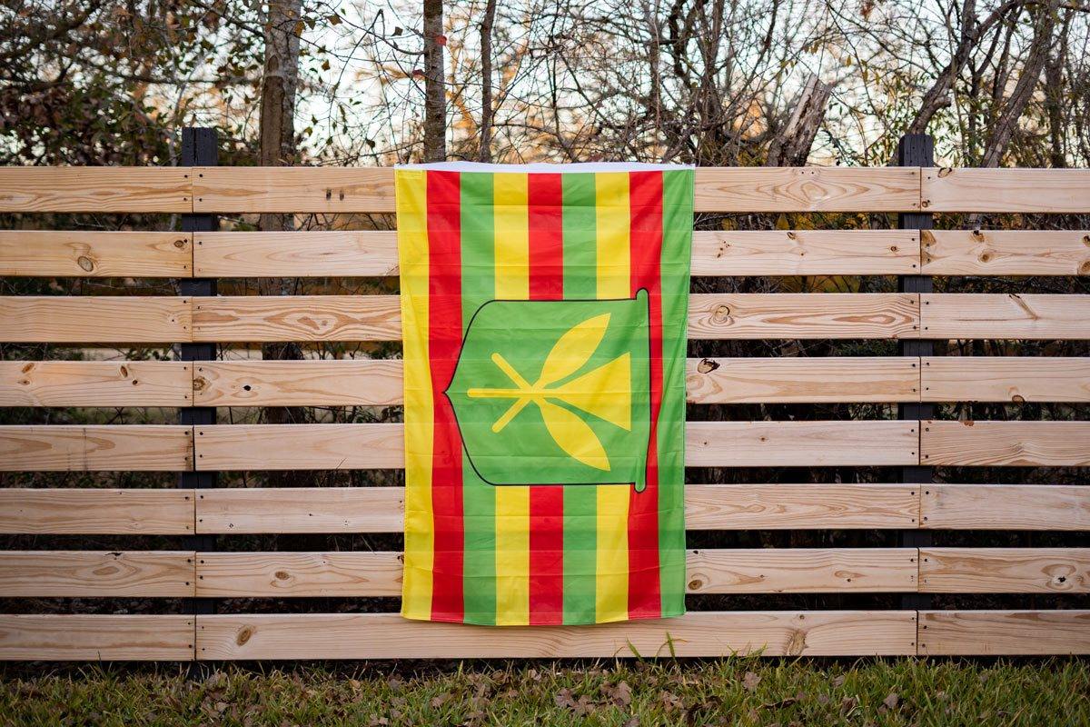 Kanaka Maoli flag displayed on a fence outdoors
