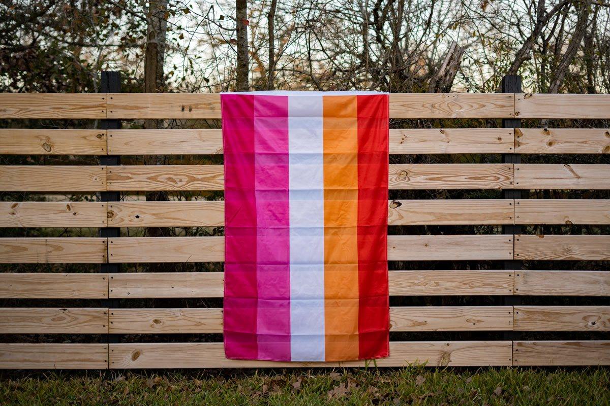 Lesbian Pride flag flying on a fence outdoors