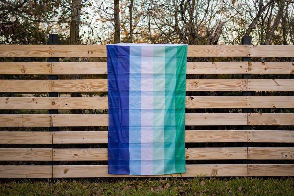 MLM Pride Flag displayed on fence outdoors