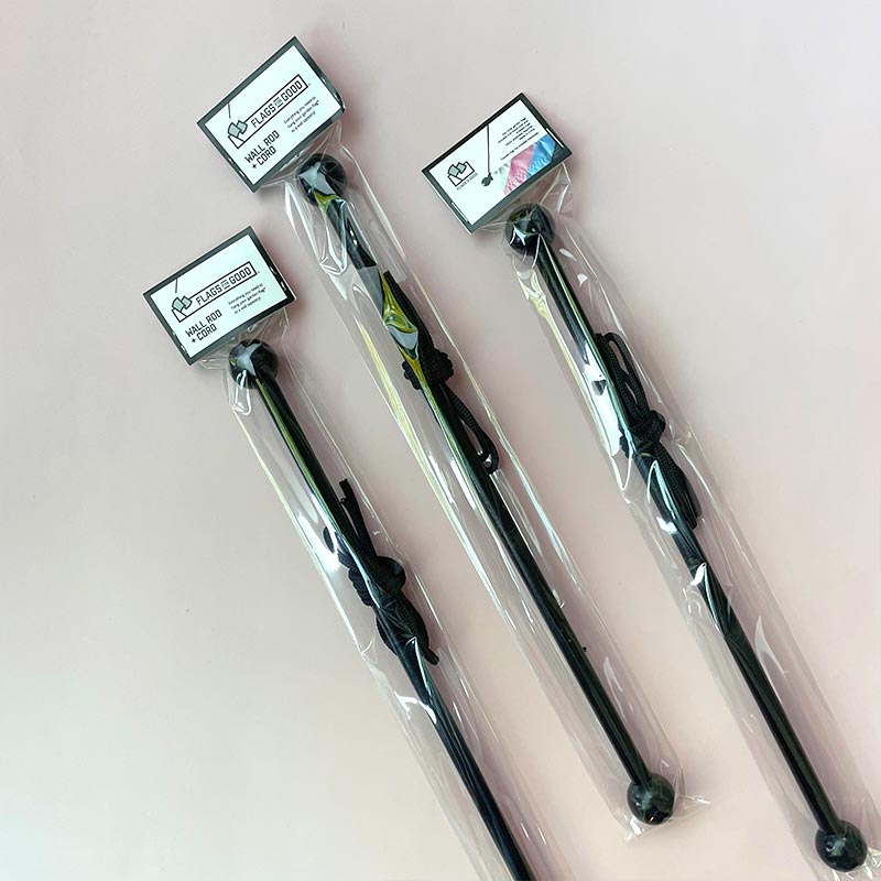 Black painted wooden wall rod with black cord — packaged, showing ball-end detail