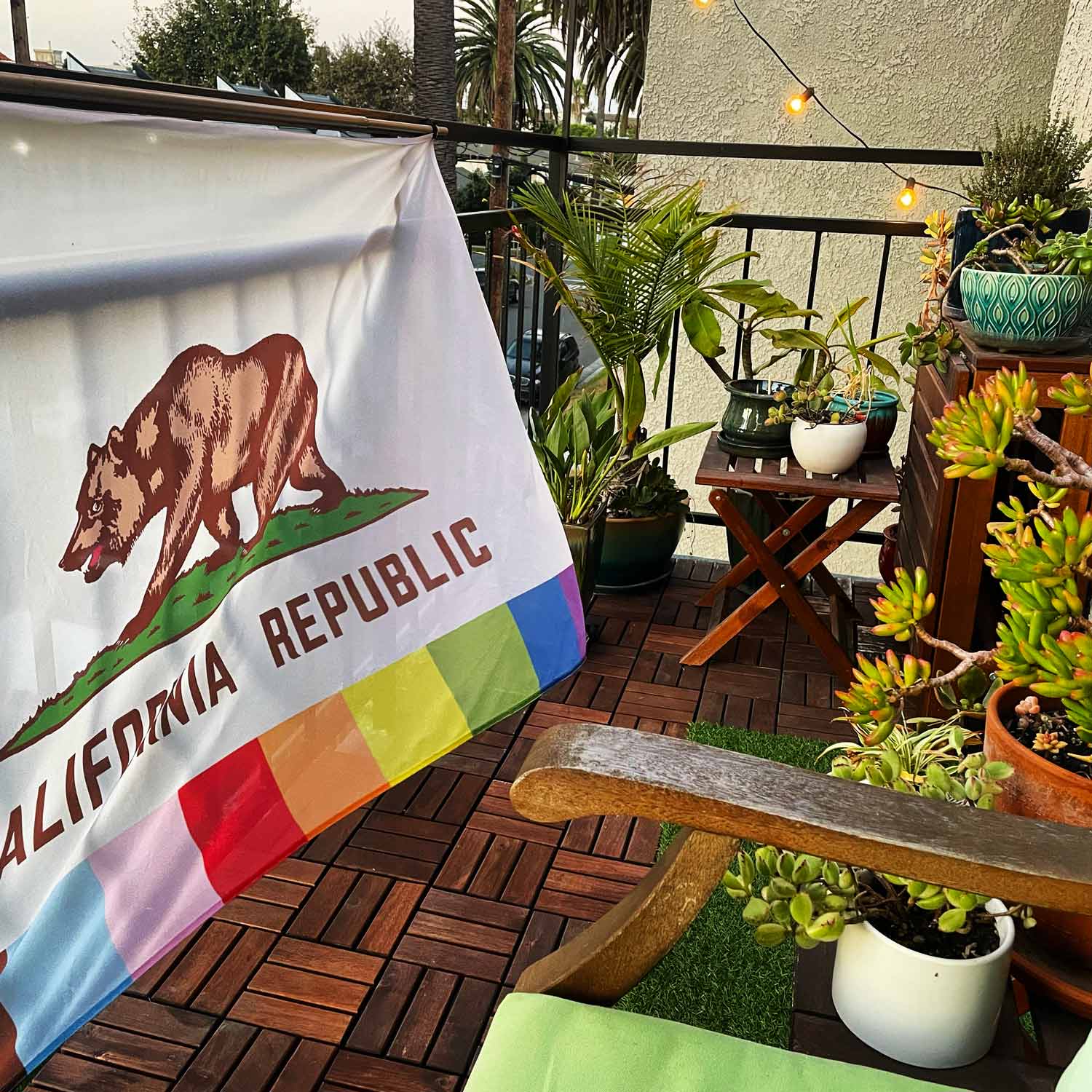 Rainbow California Pride flag hung on balcony railing outdoors