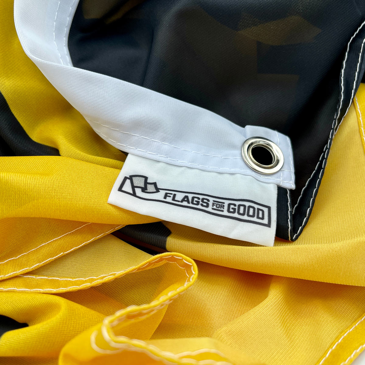 Vaccines Save Lives flag — close-up of product tag and edge stitching