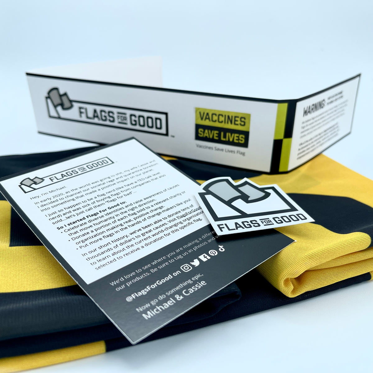 Vaccines Save Lives flag — unfolded flat lay showing full yellow and black design