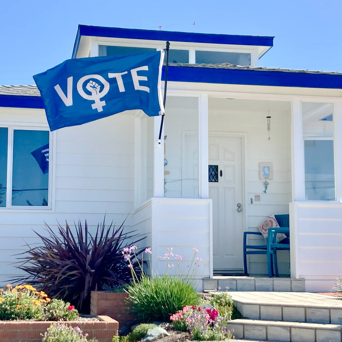 VOTE Female flag hanging on a house exterior